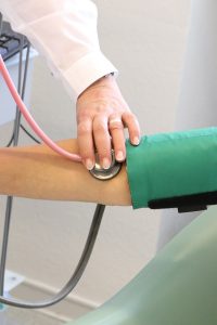 doctor taking the blood pressure of a patient